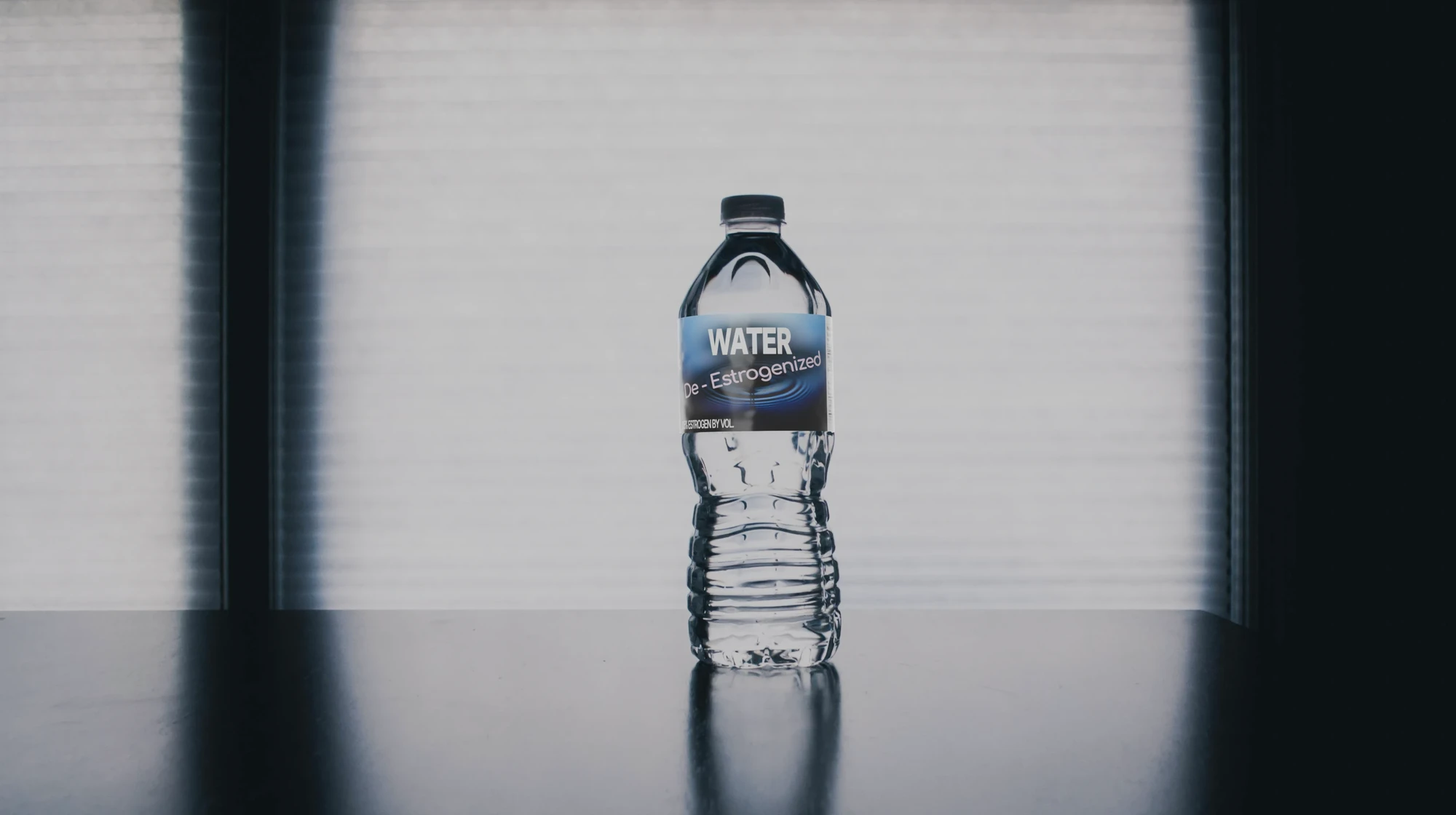 A water bottle labelled with "De-Estrogenized Water, 0.5% Estrogen by Volume"